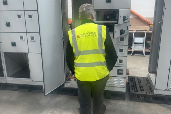 Picture of a Ben Wood Group electrical engineer in front of a panel and distribution board