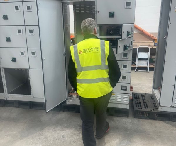 Picture of a Ben Wood Group electrical engineer in front of a panel and distribution board